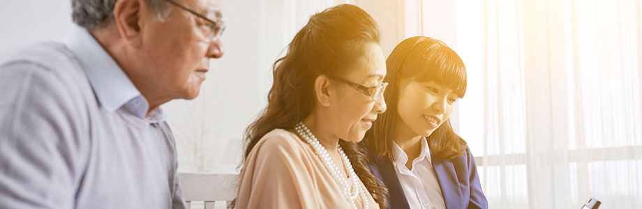 young woman helping senior parents with their tablet