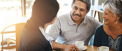 senior couple having coffee with a business woman