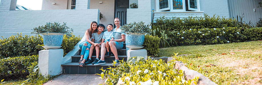 family sitting on the outdoor front steps of their home