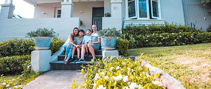 family sitting on the outdoor front steps of their home