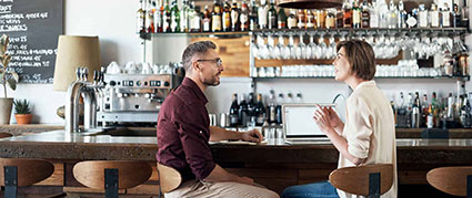 male and female talking at a restaurant counter