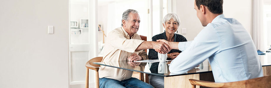 middle aged couple shaking hands with young man