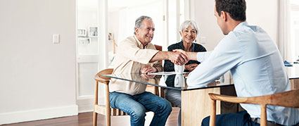 middle aged couple shaking hands with young man
