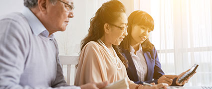 young woman helping senior parents with their tablet