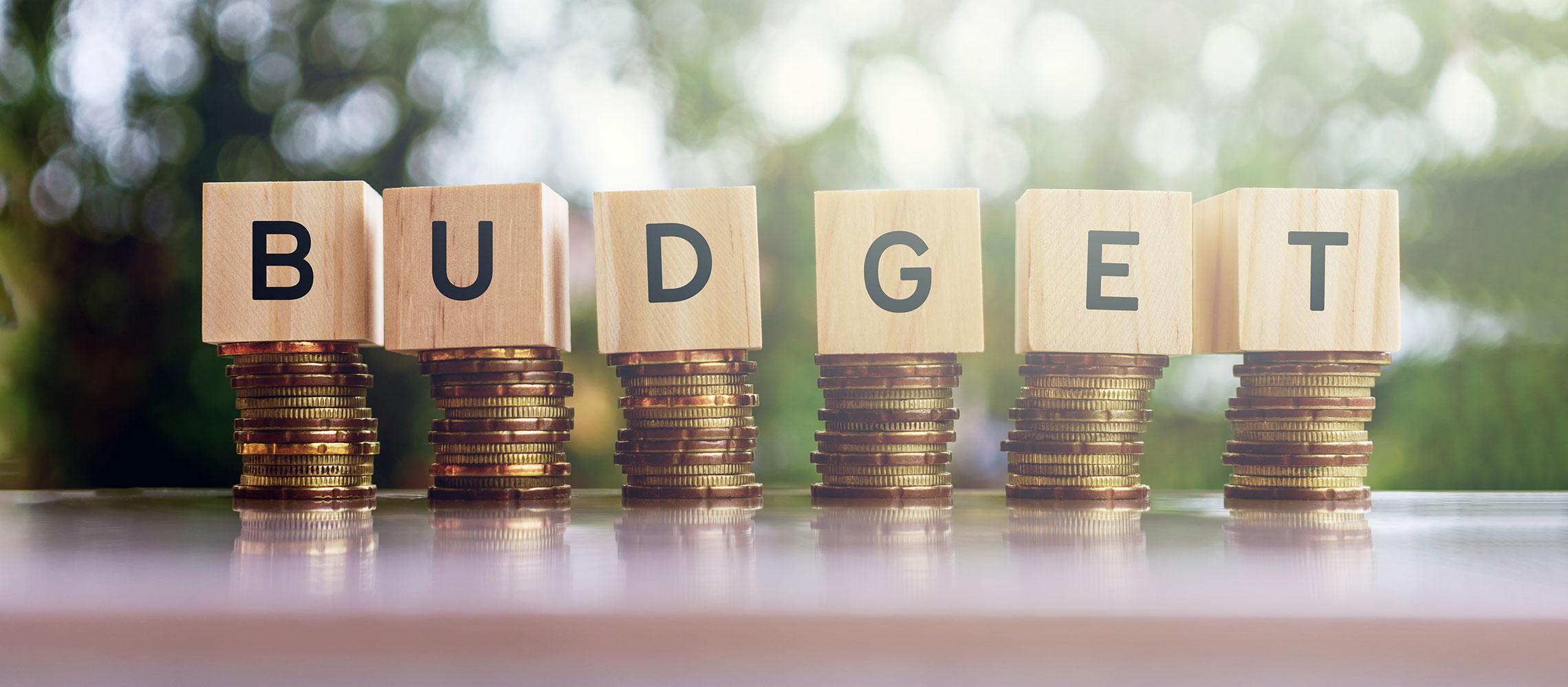 budget spelled in blocks standing on stack of coins