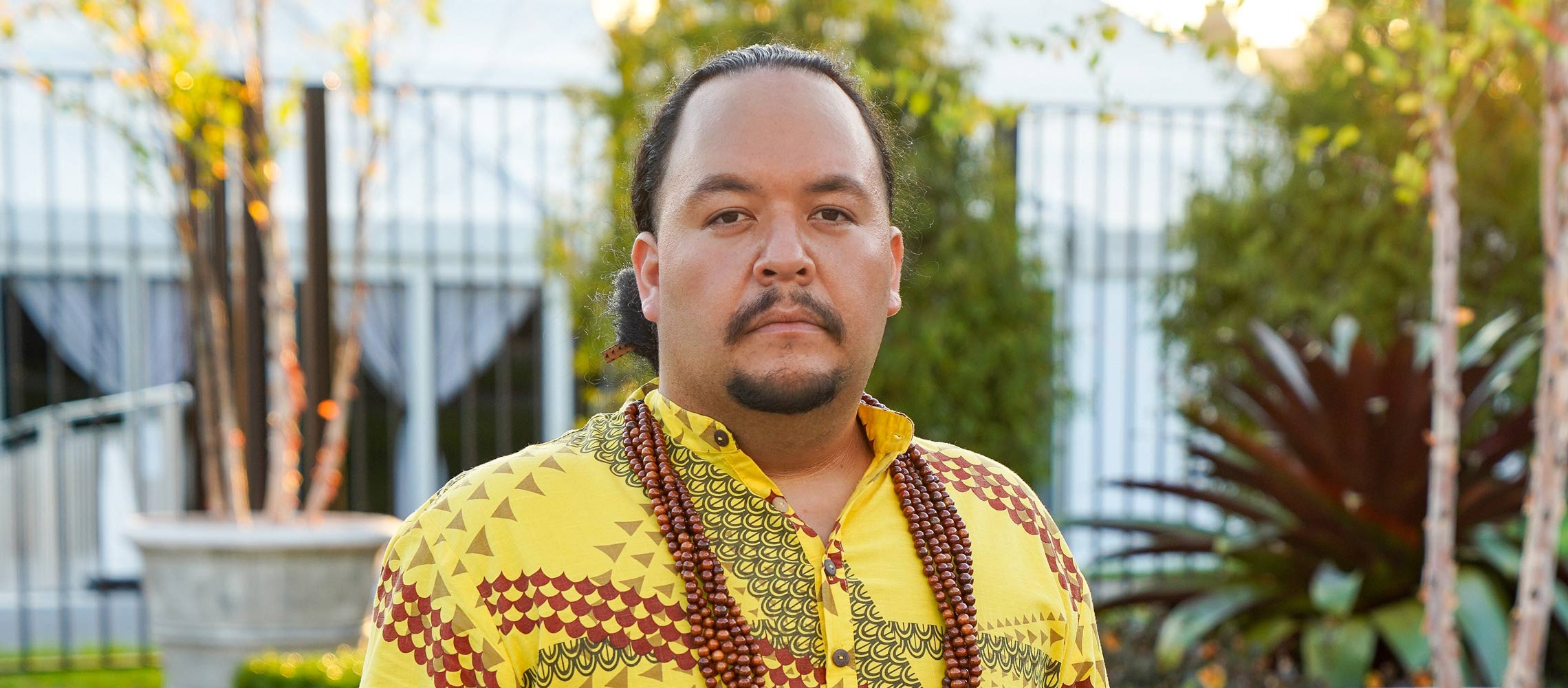 Kumu Micah Kamohoalii in yellow top with a lei