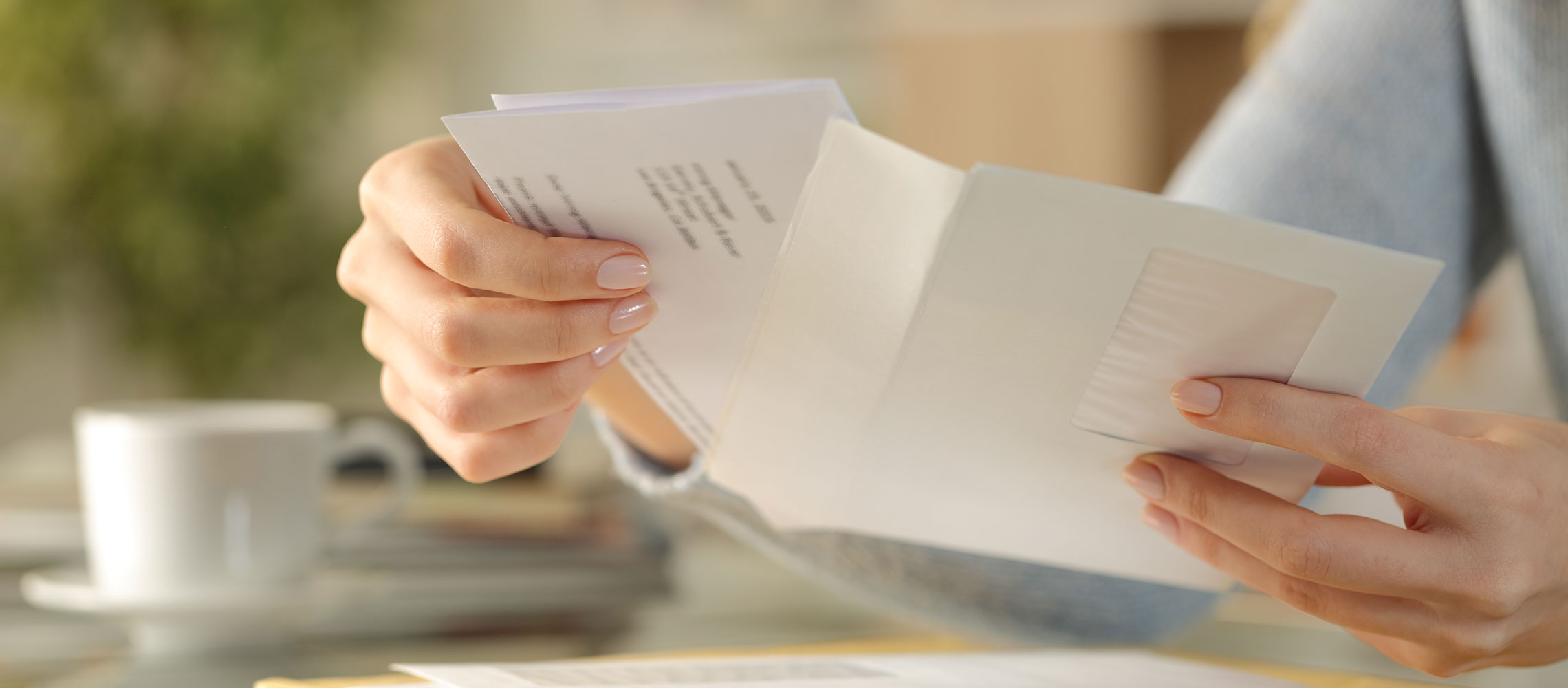 close up of a woman opening mail, watch out for fake check scams