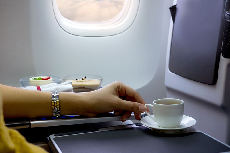 woman's had holding coffee cup on flight