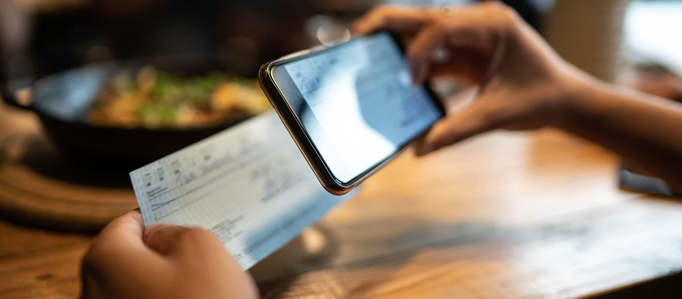 person taking a photo of check for mobile deposit