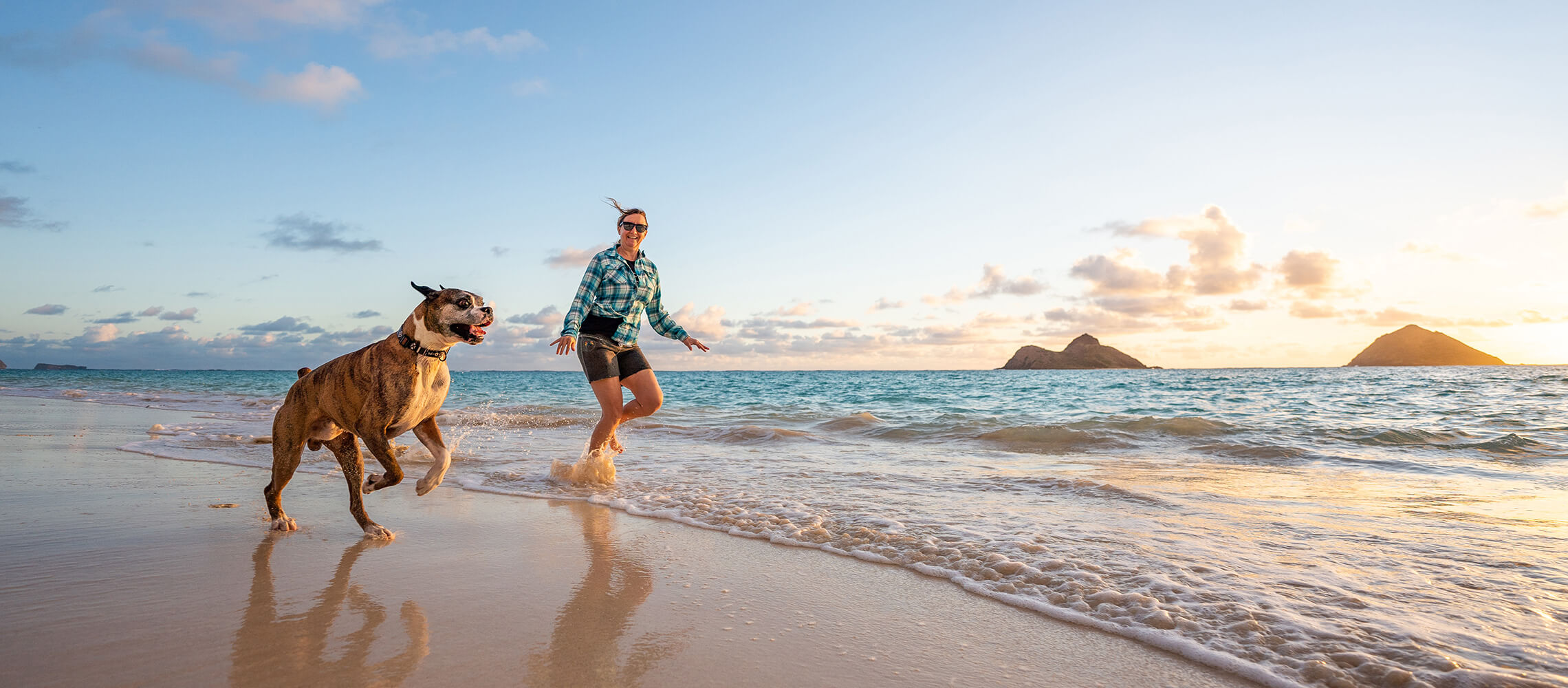 woman and dog running on Lanikai beach