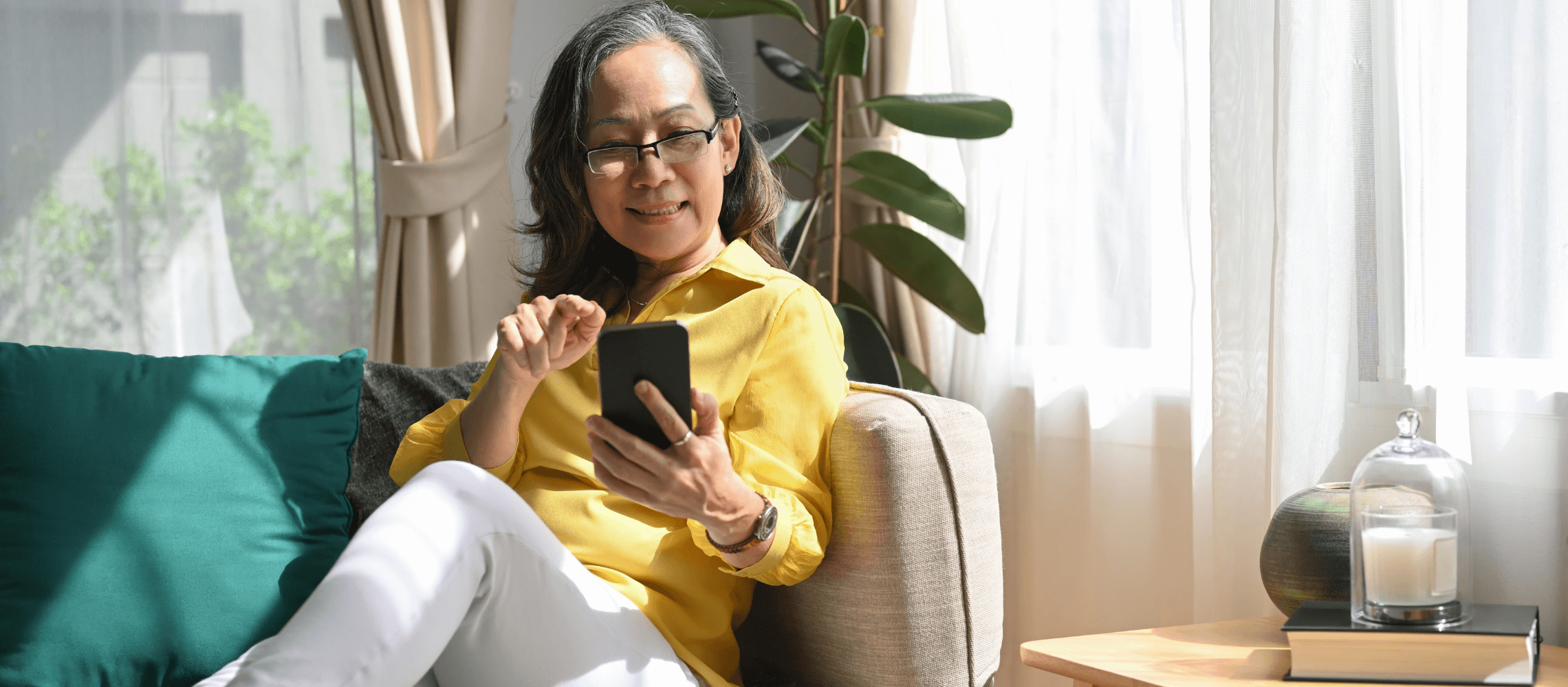 woman on couch looking at mobile phone