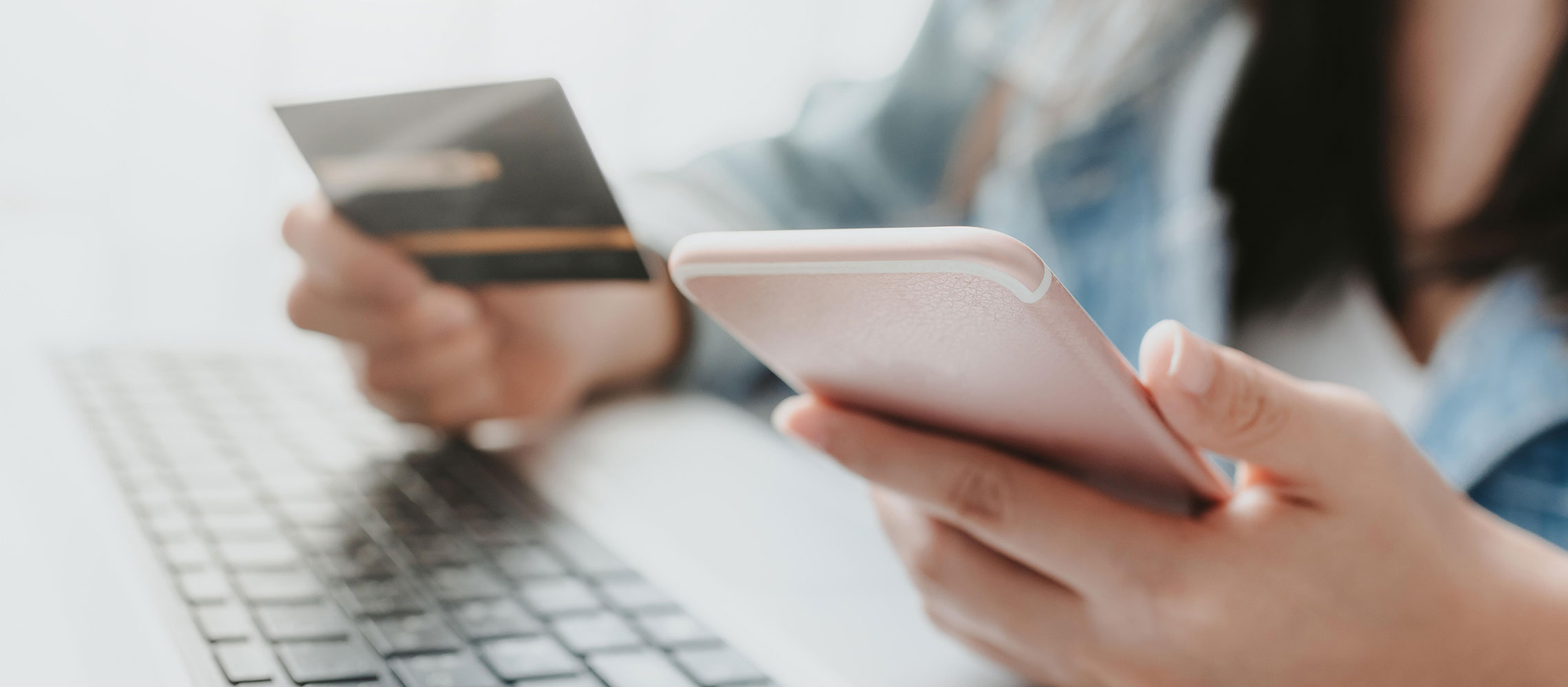 woman working with her laptop, smartphone and debit card