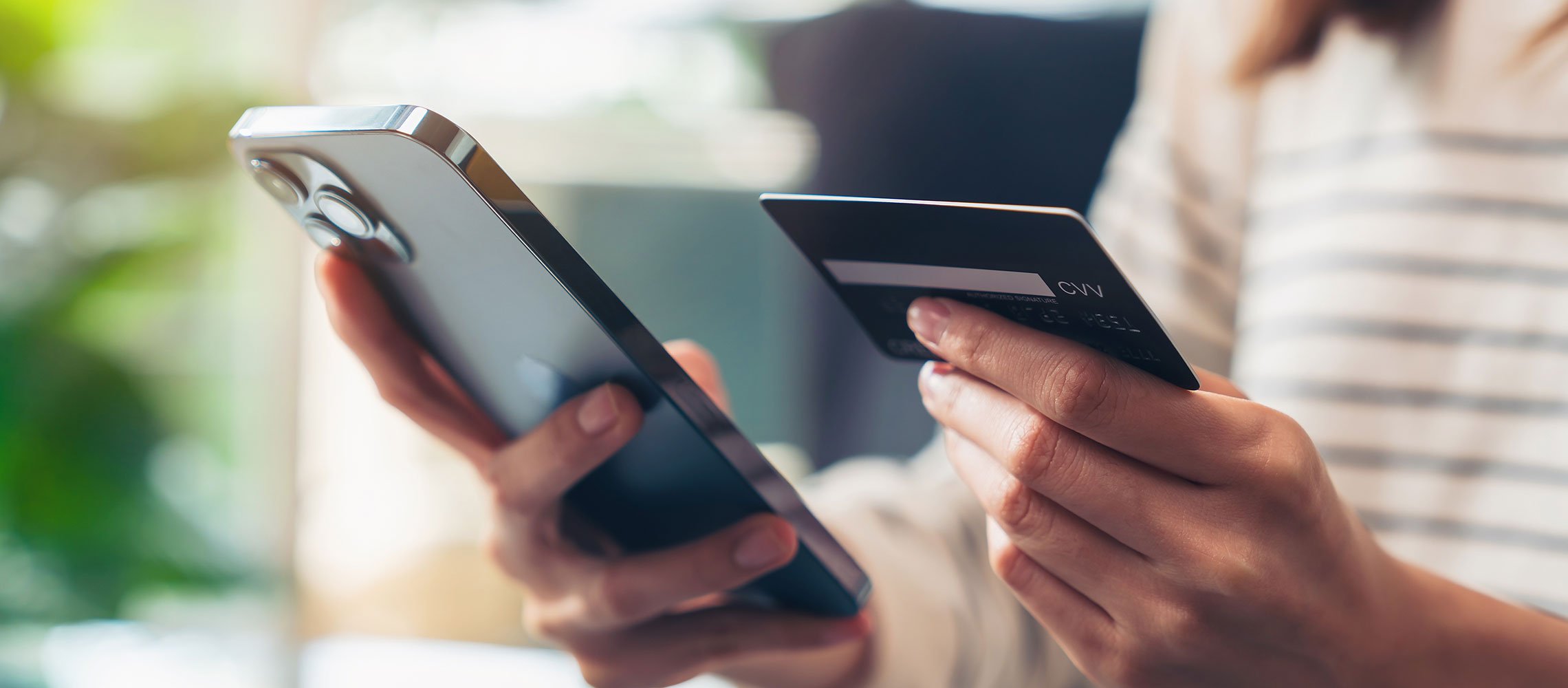 person holding credit card and iphone