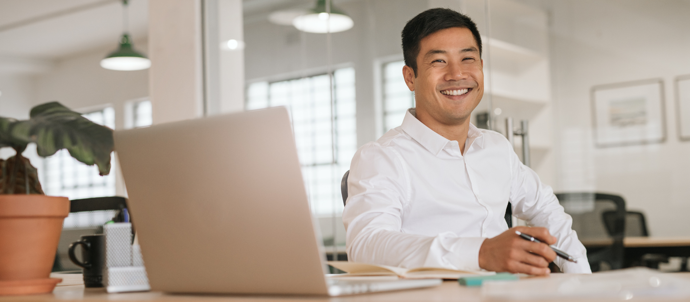 Man at desk with laptop smiling