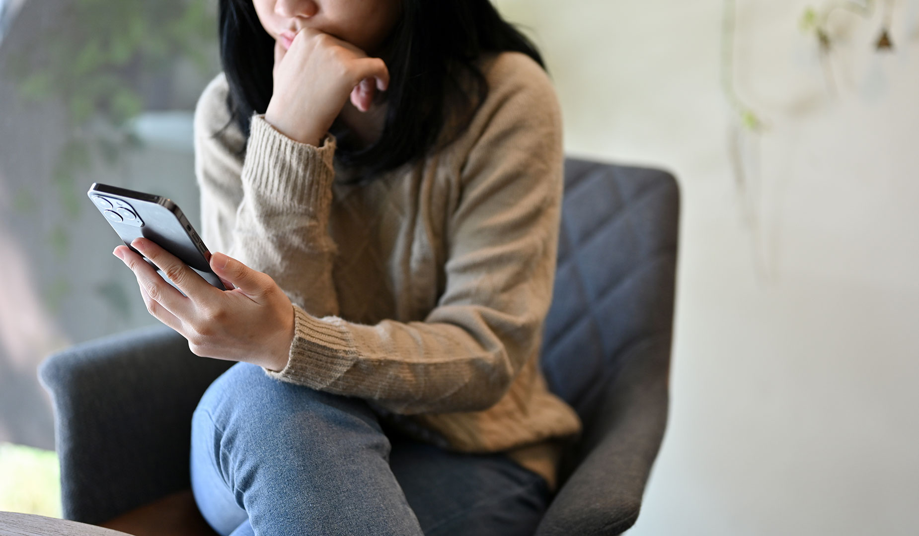 woman sitting while looking at mobile phone