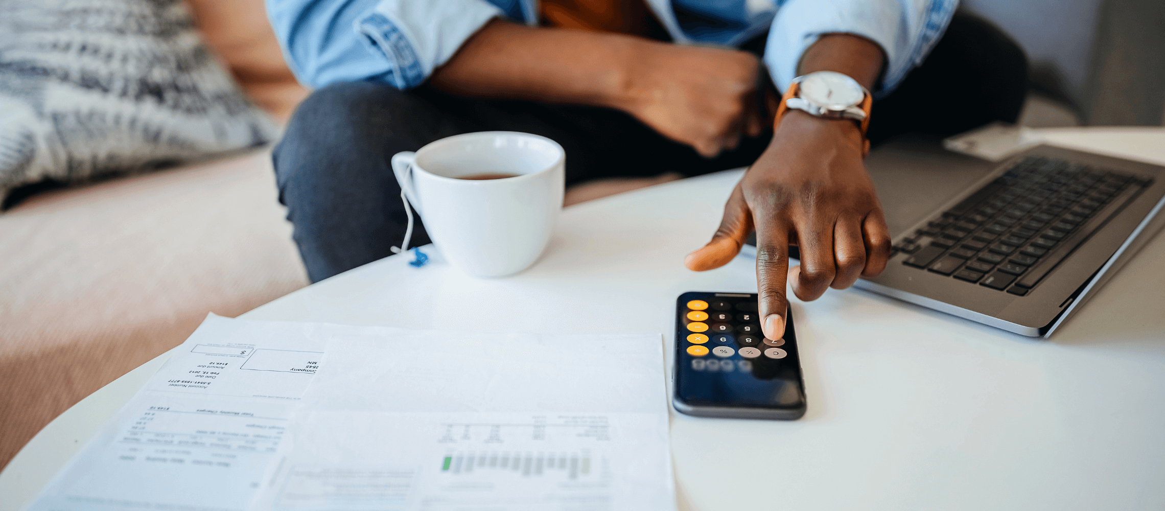 Man with calculator and paperwork on table