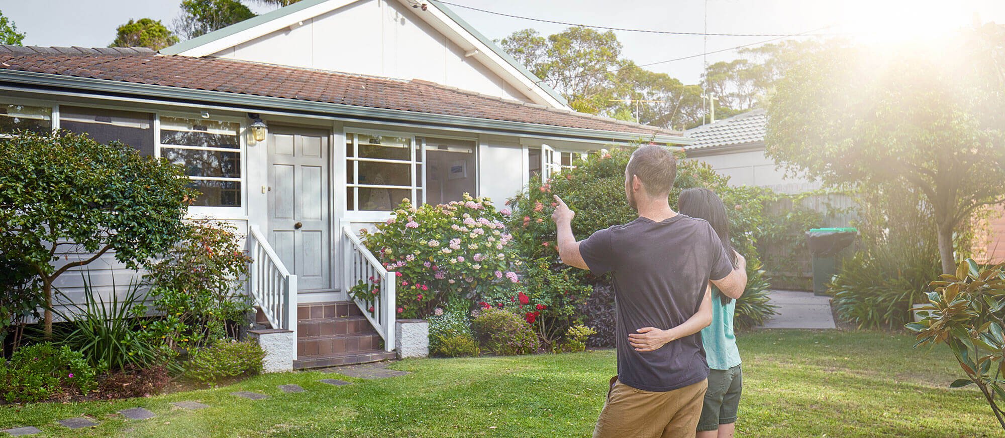couple pointing at house