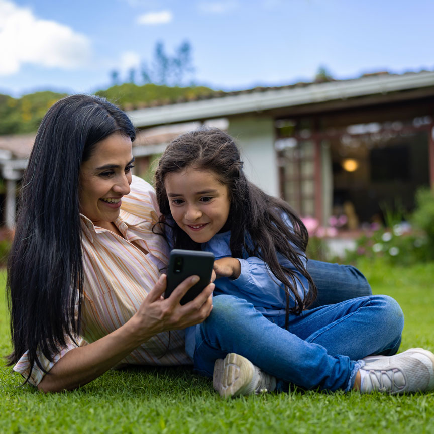 mom and daugther in a yard looking at mobile phone