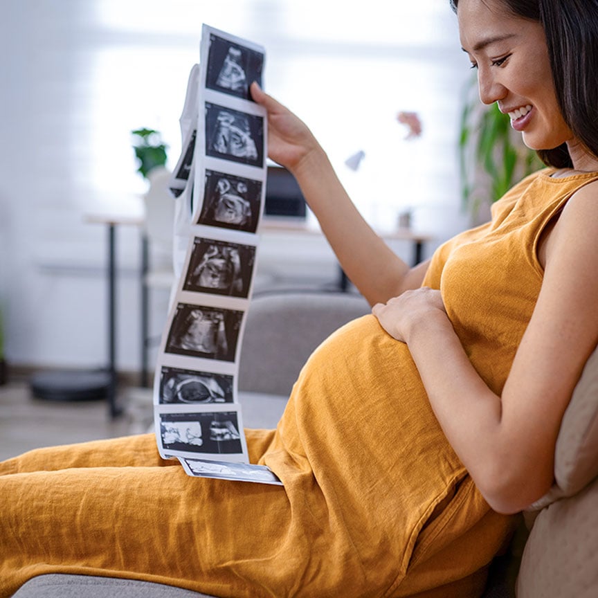 pregnant mother holding sonogram pictures
