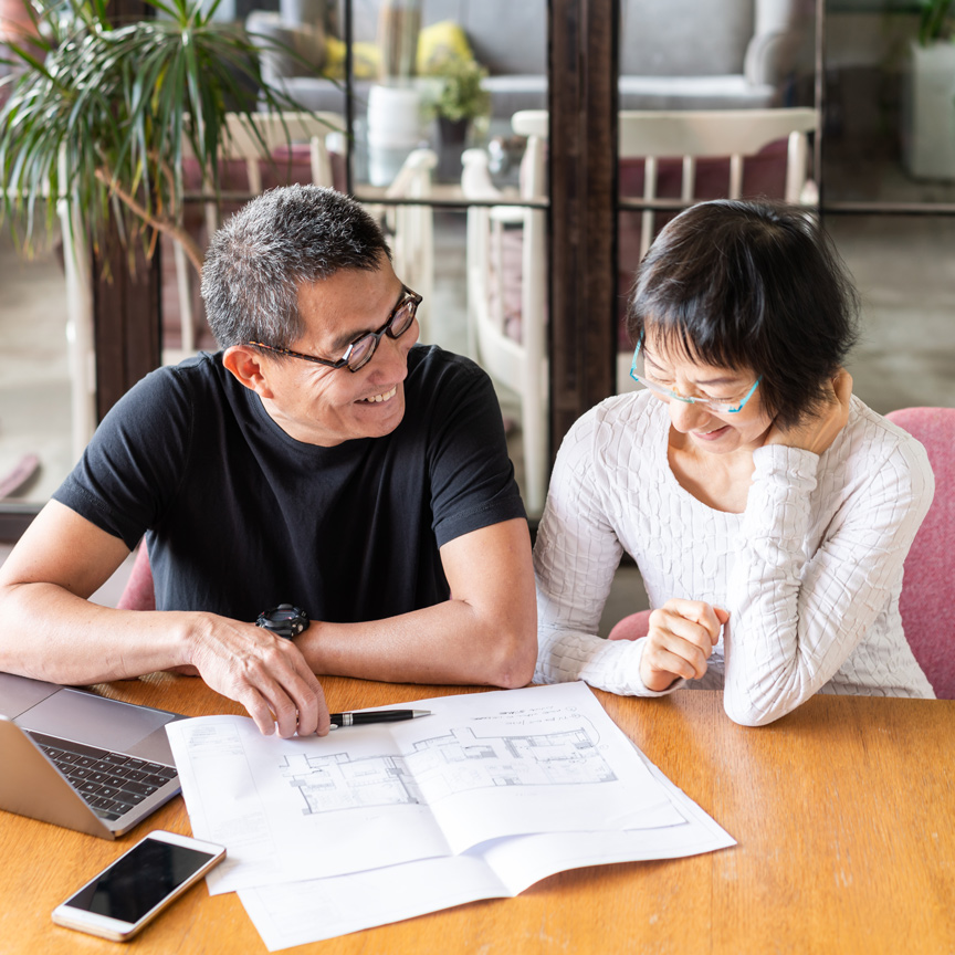 senior couple sitting at desk reviewing mortgage