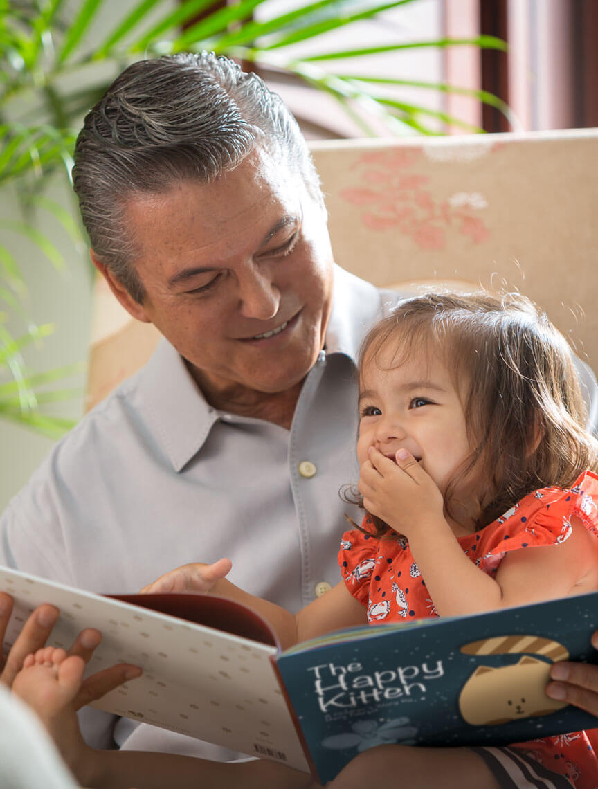 grandfather reading to grand daughter