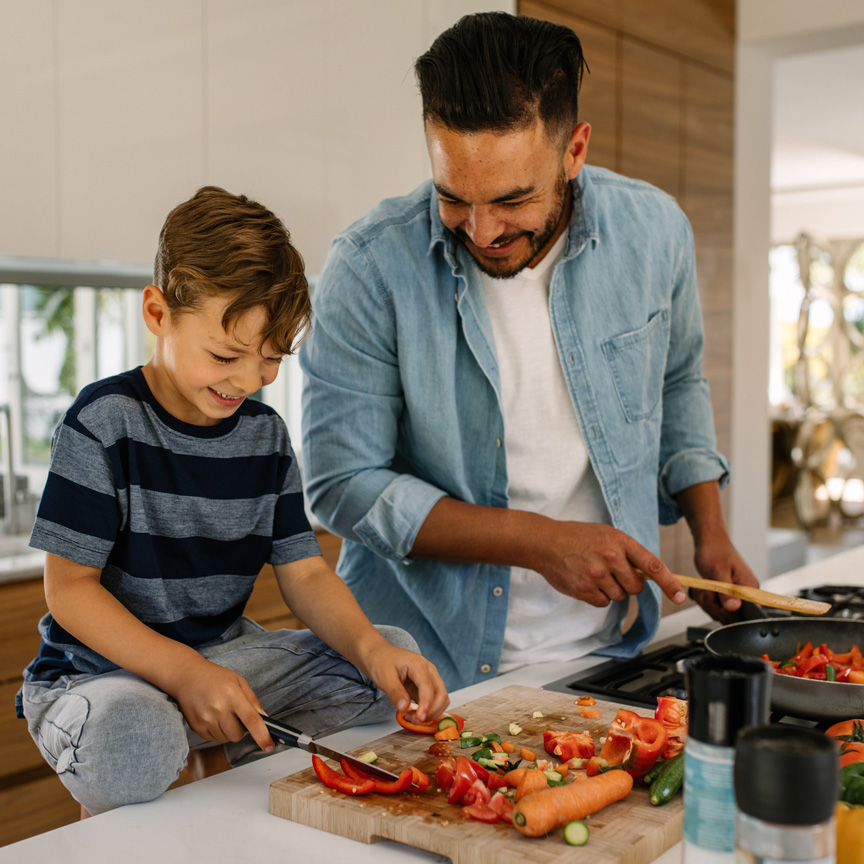 father and son prepping food in kitchen