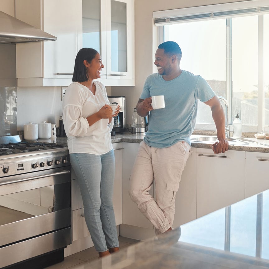 Couple standing in their home kitchen