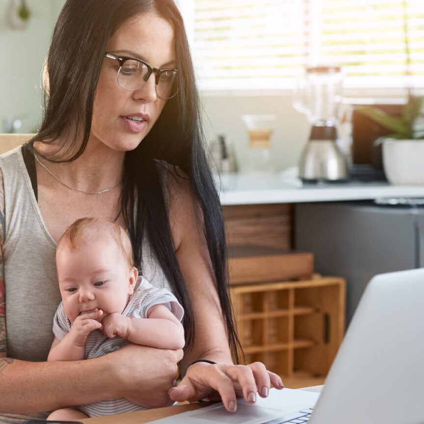 woman with infant using laptop