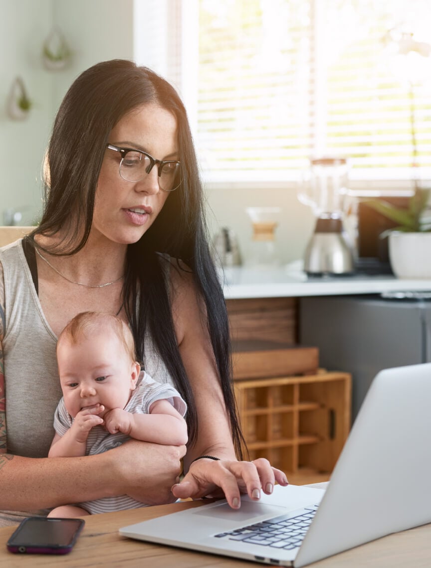 woman with infant using laptop