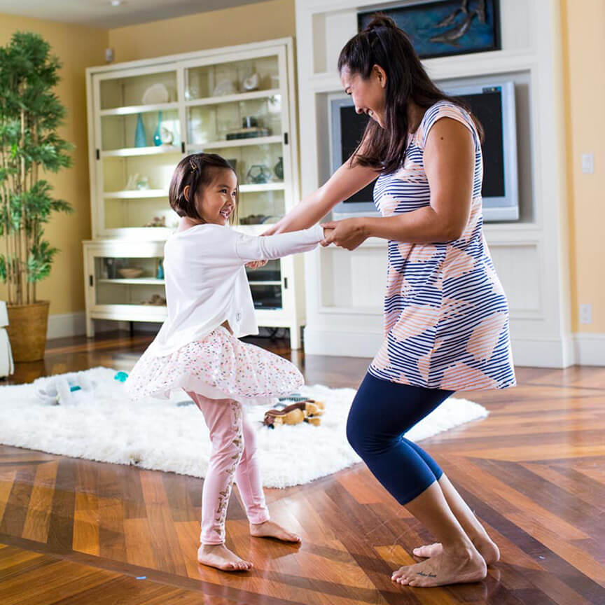 mother dancing with daughter at home