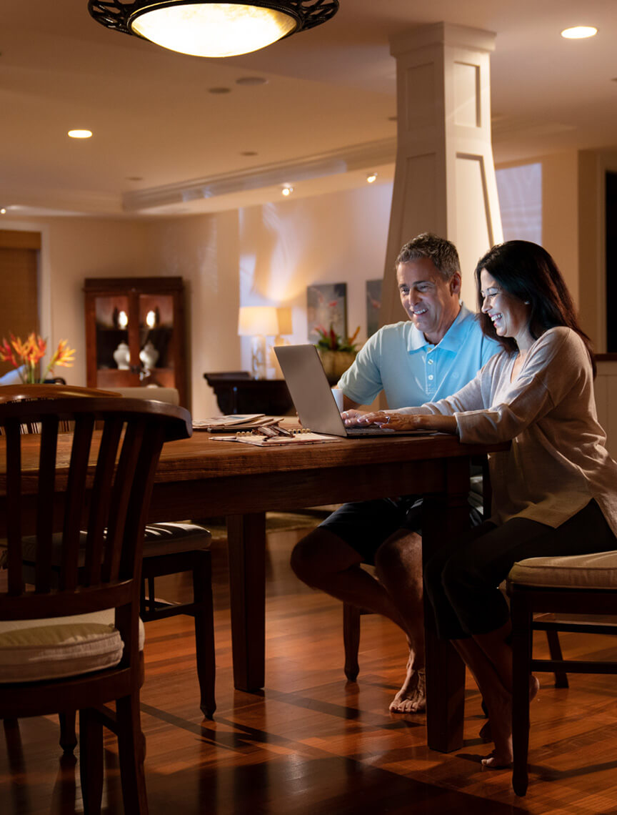 couple in dining room using laptop