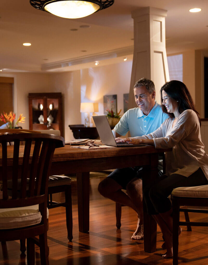 couple in dining room using laptop