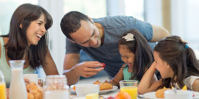family of four eating breakfast together