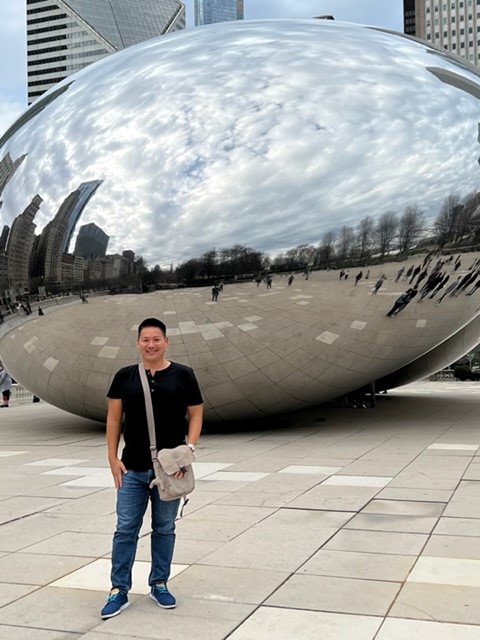Man standing in front of the Bean sculpture in Chicago.